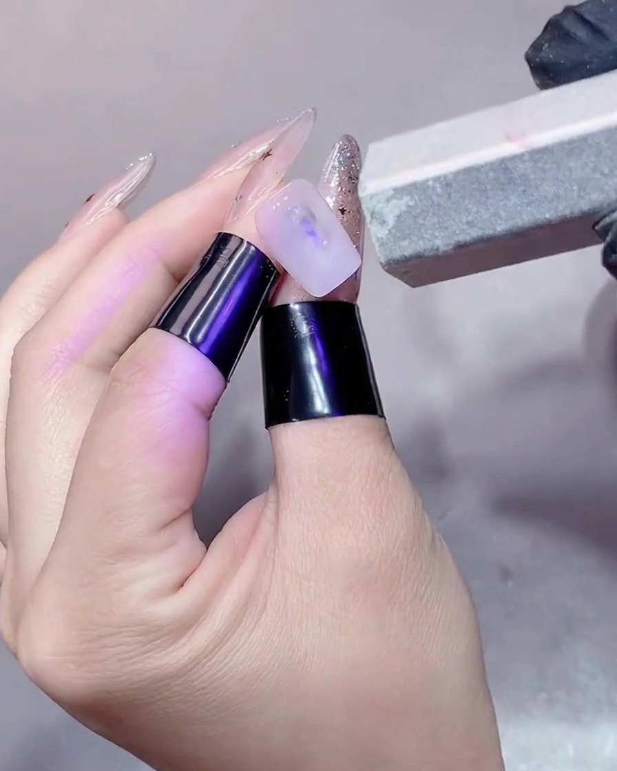 Nahaufnahme eines Nagels, der mit einem Block-Buffer geglättet wird.