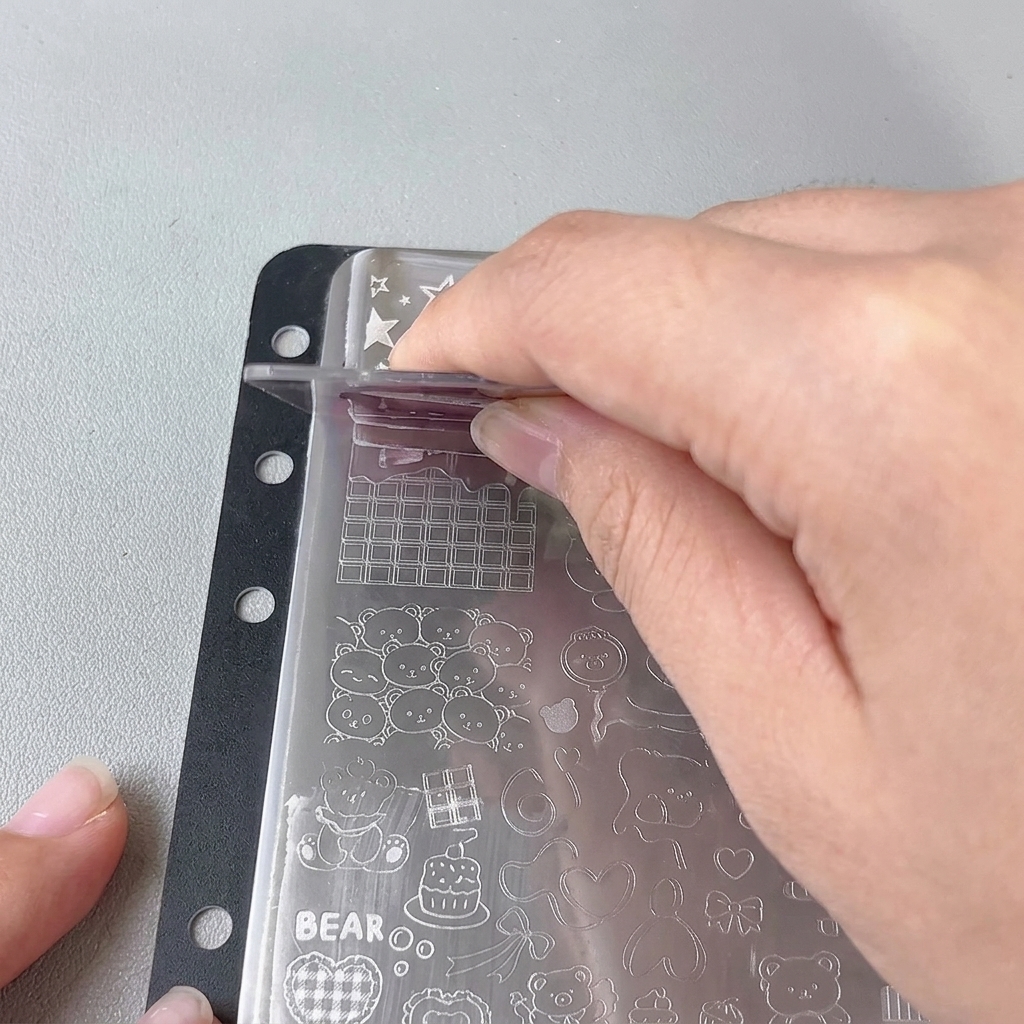 Ein transparenter Jelly-Stamper wird auf das Design einer Metallschablone gedrückt.