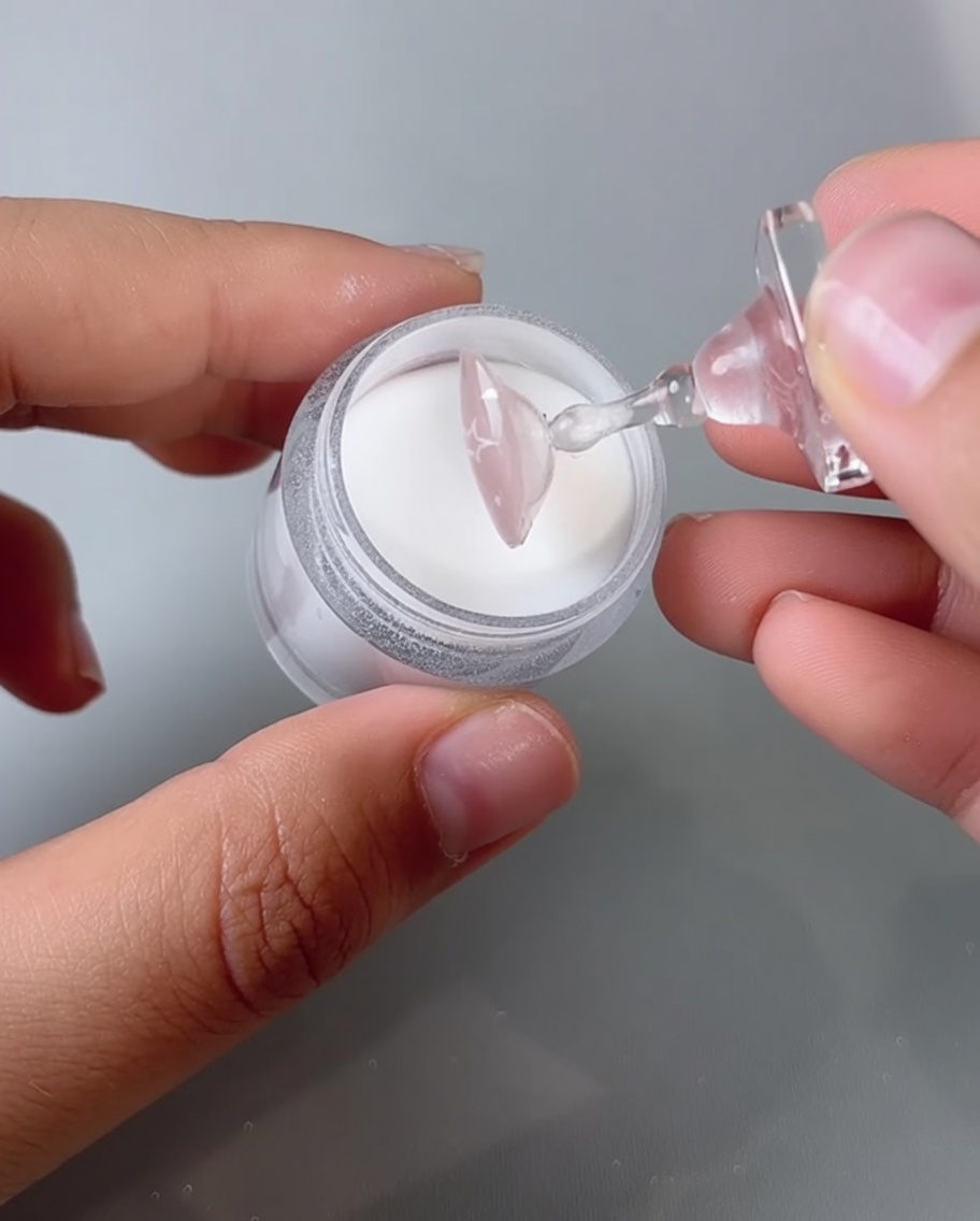 Ein Fingernagel wird zum Aushärten in eine UV-/LED-Nagellampe gelegt.