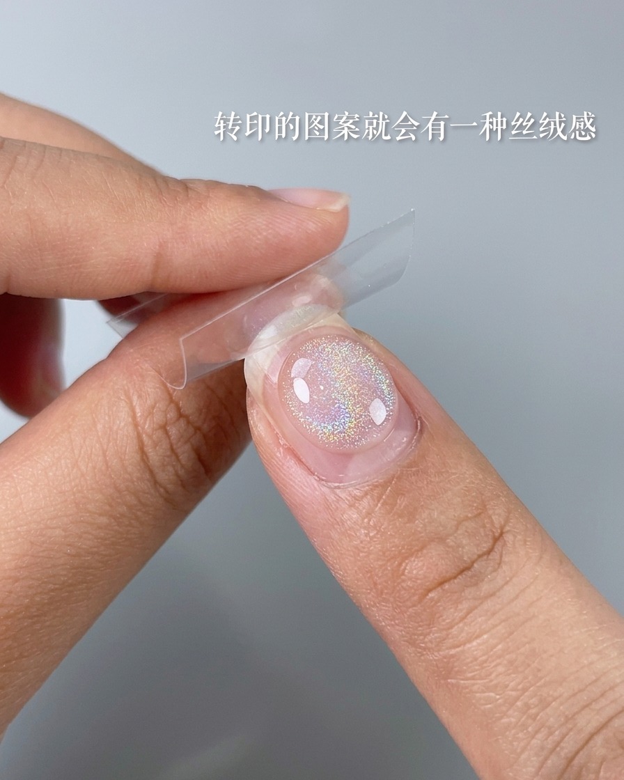 Nahaufnahme eines weichen Pinsels, der überschüssiges Puder von einem fertigen Nageldesign abbürstet.