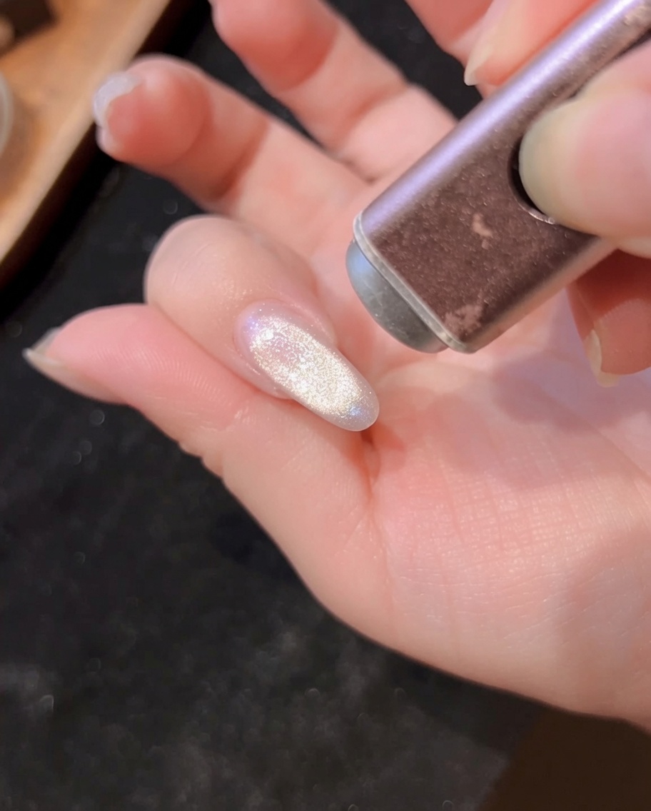 Nahaufnahme einer Hand in der UV/LED-Lampe bei der Aushärtung des Cat-Eye-Gels.