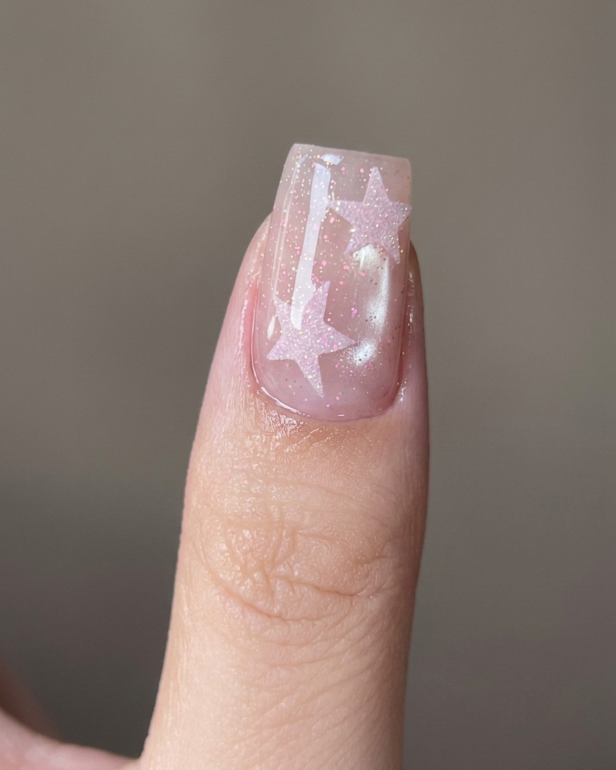 Ein Nagelhautschieber aus Metall reinigt vorsichtig den Nagelhautbereich an einem Naturnagel.