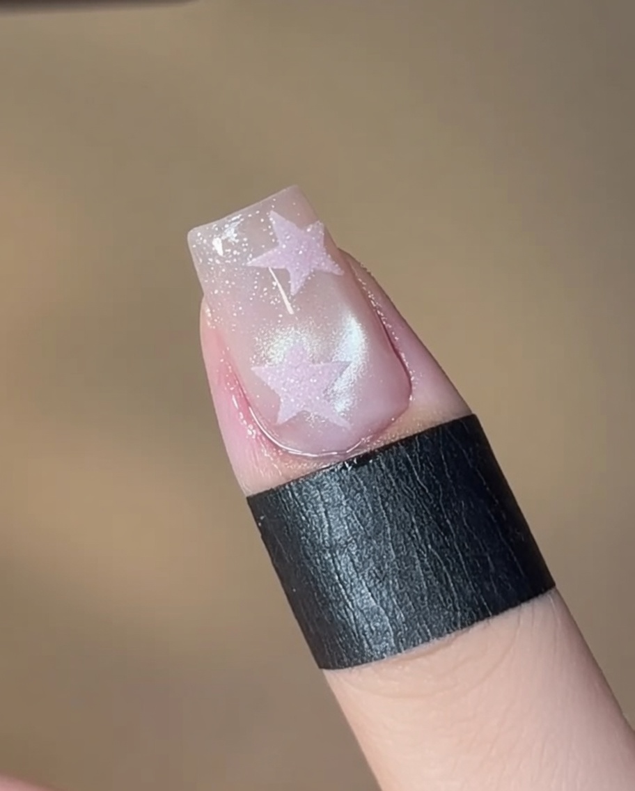 Ein Pinsel trägt ein schimmerndes 05 Cat-Eye-Gel auf den sauberen Nagel auf.