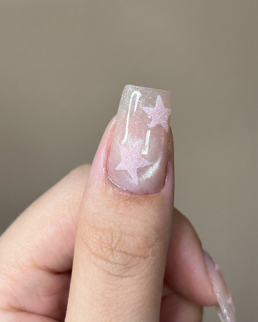 Ein Pinsel trägt einen klaren Top Coat über den schimmernden Cat-Eye-Nagel auf.