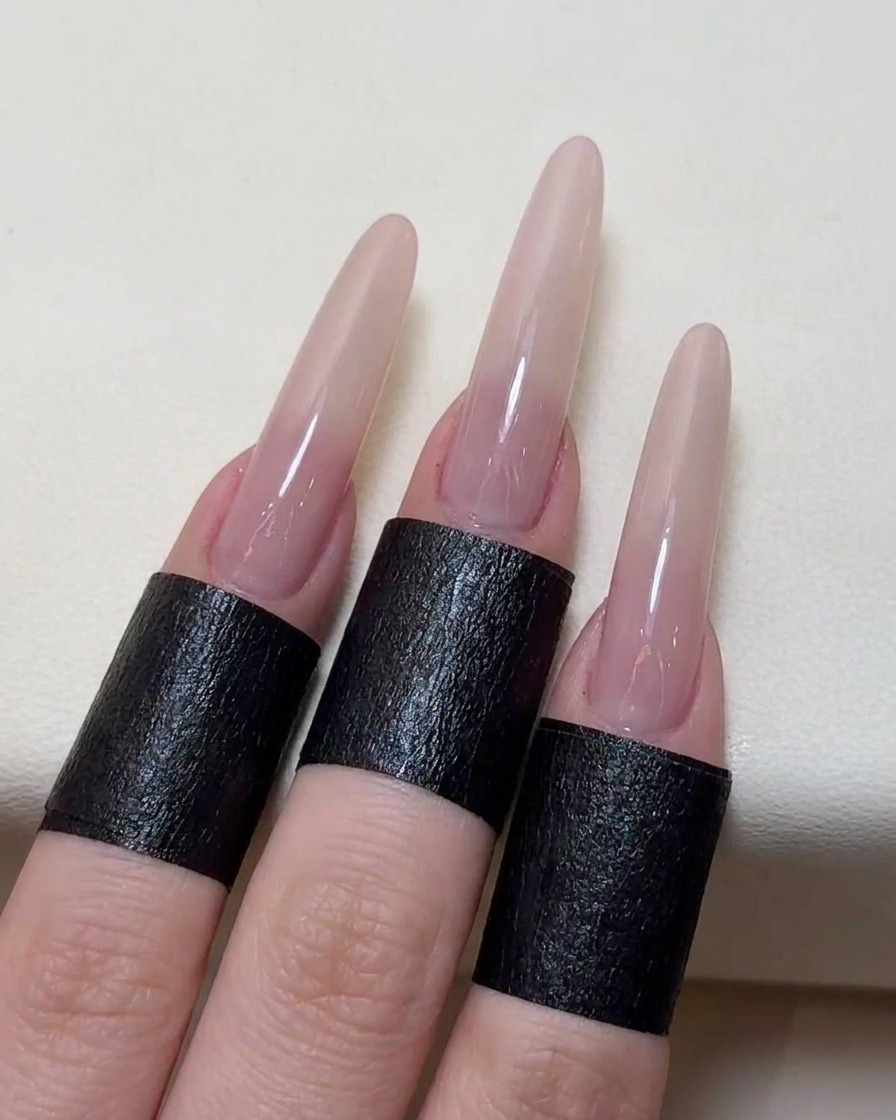 Eine Pinzette platziert ein filigranes Rosen-Sticker-Stencil mittig auf dem nude-farbenen Nagel.