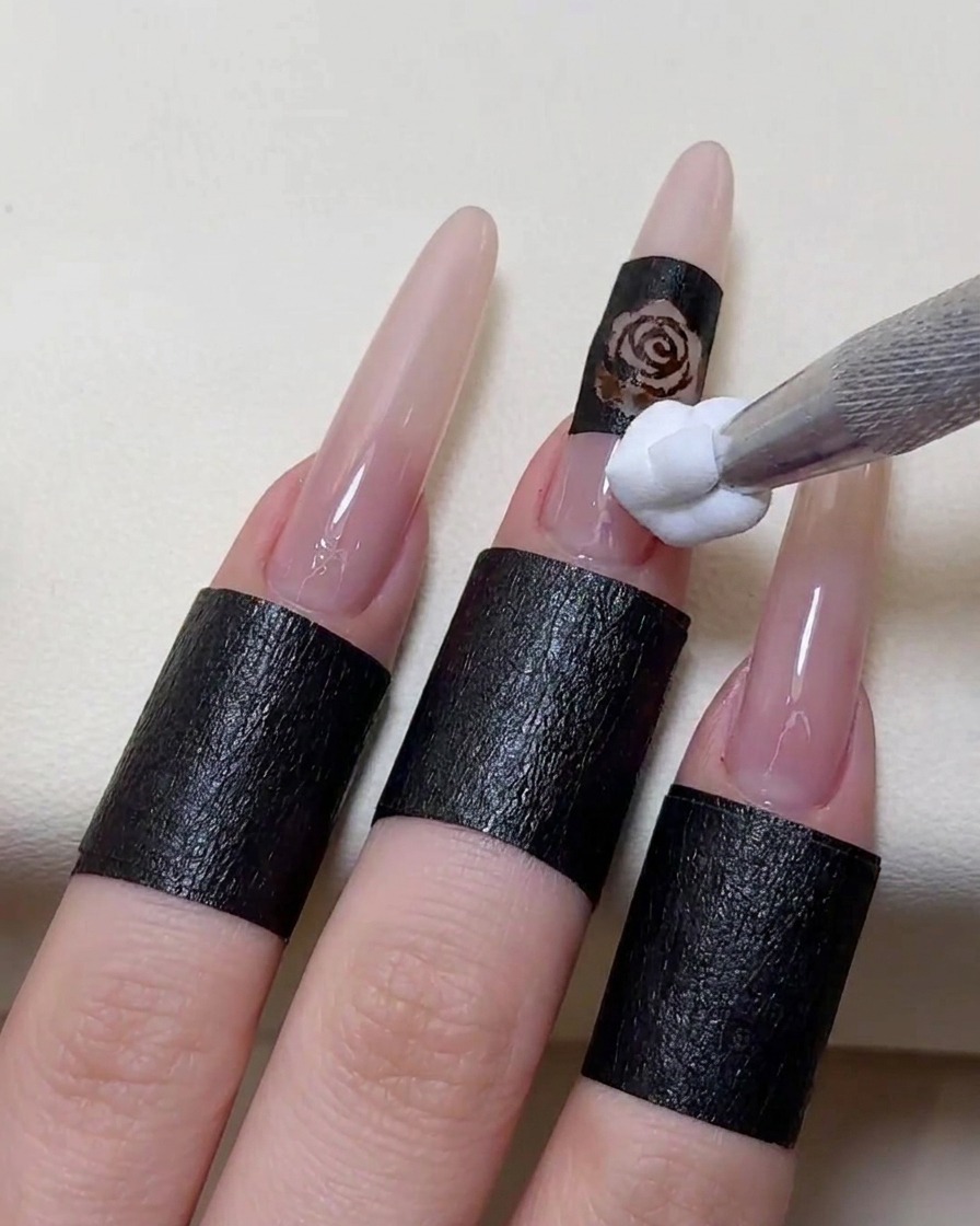 Ein Schwämmchen-Applikator tupft weißes Gel auf die Schablone auf dem Nagel.