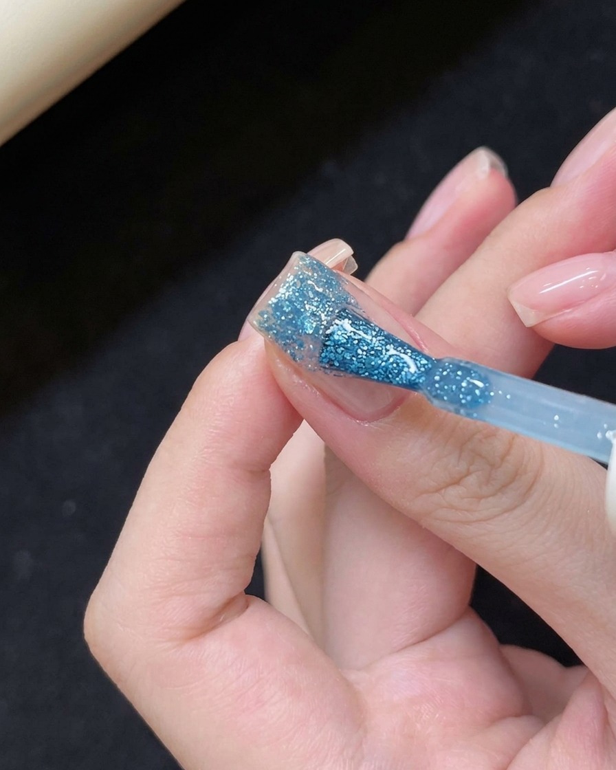 Auftragen von blauem Gel auf die Nagelspitze.