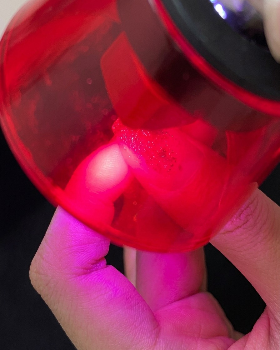 Ein Pinsel trägt klaren Top Coat über das Design auf.