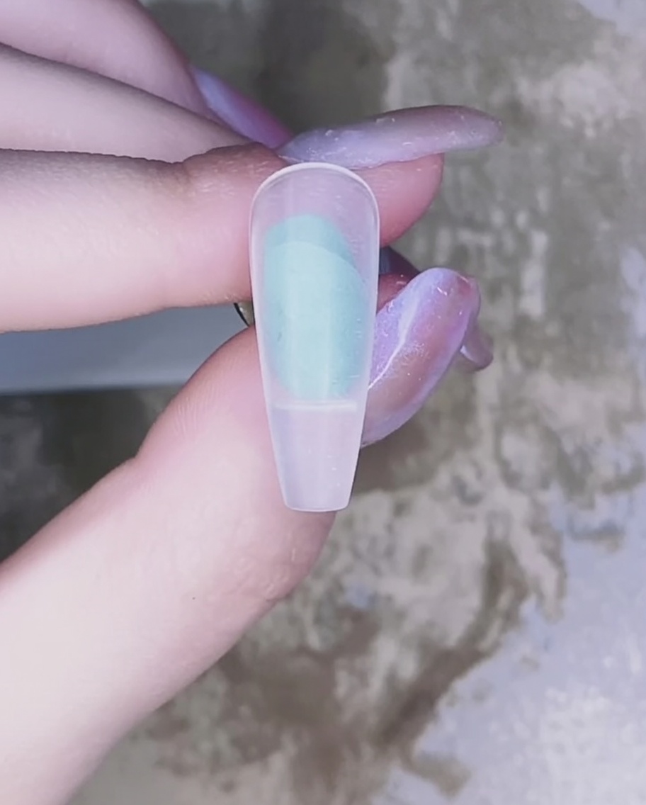 Nahaufnahme: Pinsel trägt transparentes rosa Gel auf einen Naturnagel auf.