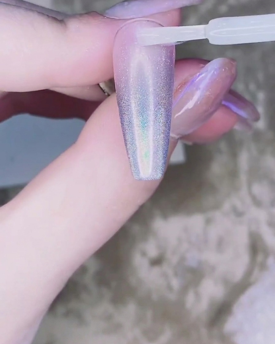 Ein winziger Tropfen klares Klebegel wird in der Mitte des Nagels platziert.