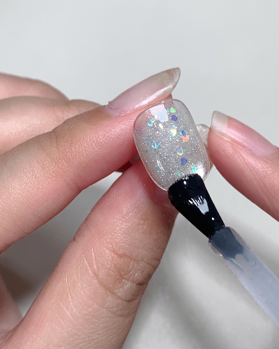 Auftragen einer klaren, dünnen Schicht Blooming-Gel auf die Oberfläche des Nagels mit einem Pinsel.