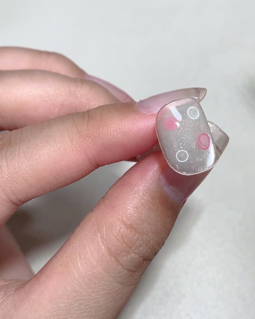 Eine Nahaufnahme eines Fingernagels, der unter einer professionellen UV-Nagellampe ausgehärtet wird.