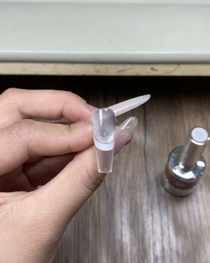Nahaufnahme einer kleinen Flasche mit speziellem Chrome-Top-Coat auf einer Holzoberfläche.