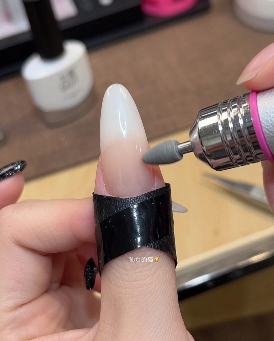 Close-up eines Pinsels beim Auftragen der zweiten Schicht nude-pinkem Gel-Lack.