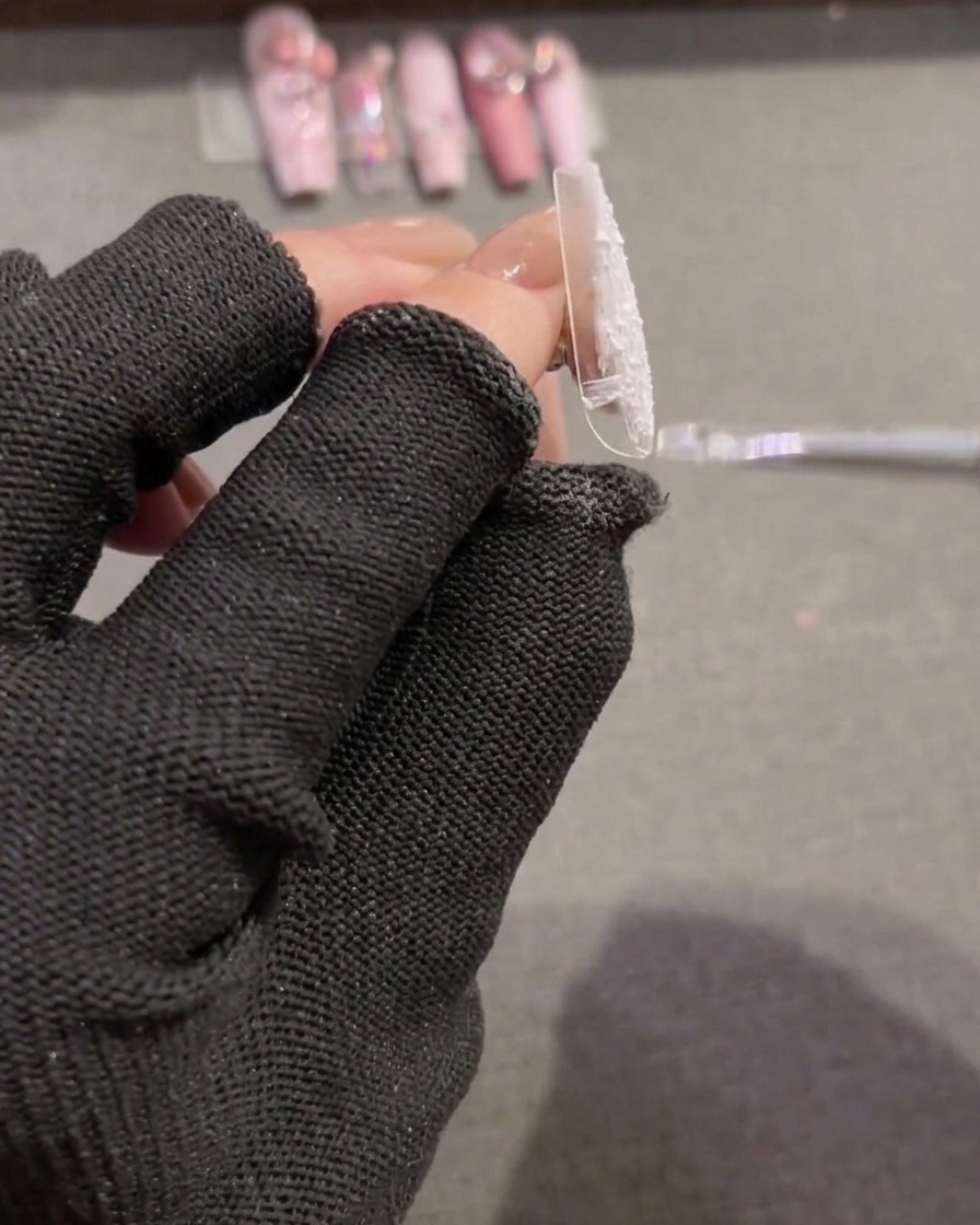 Ein Pinsel verteilt weißes, texturiertes Plaster-Gel auf einem neuen Tip für eine vollflächige Basis.