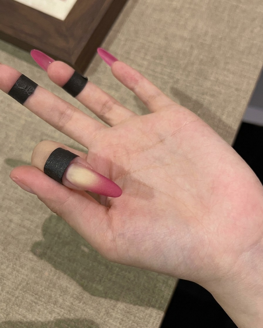 Eine Hand unter einer UV-Lampe für den letzten Schritt des matten Velvet-Looks.
