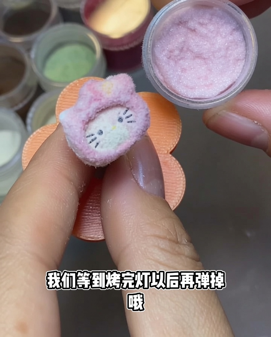 Ein Hello Kitty Nagelanhänger unter einer tragbaren UV-Nagellampe.