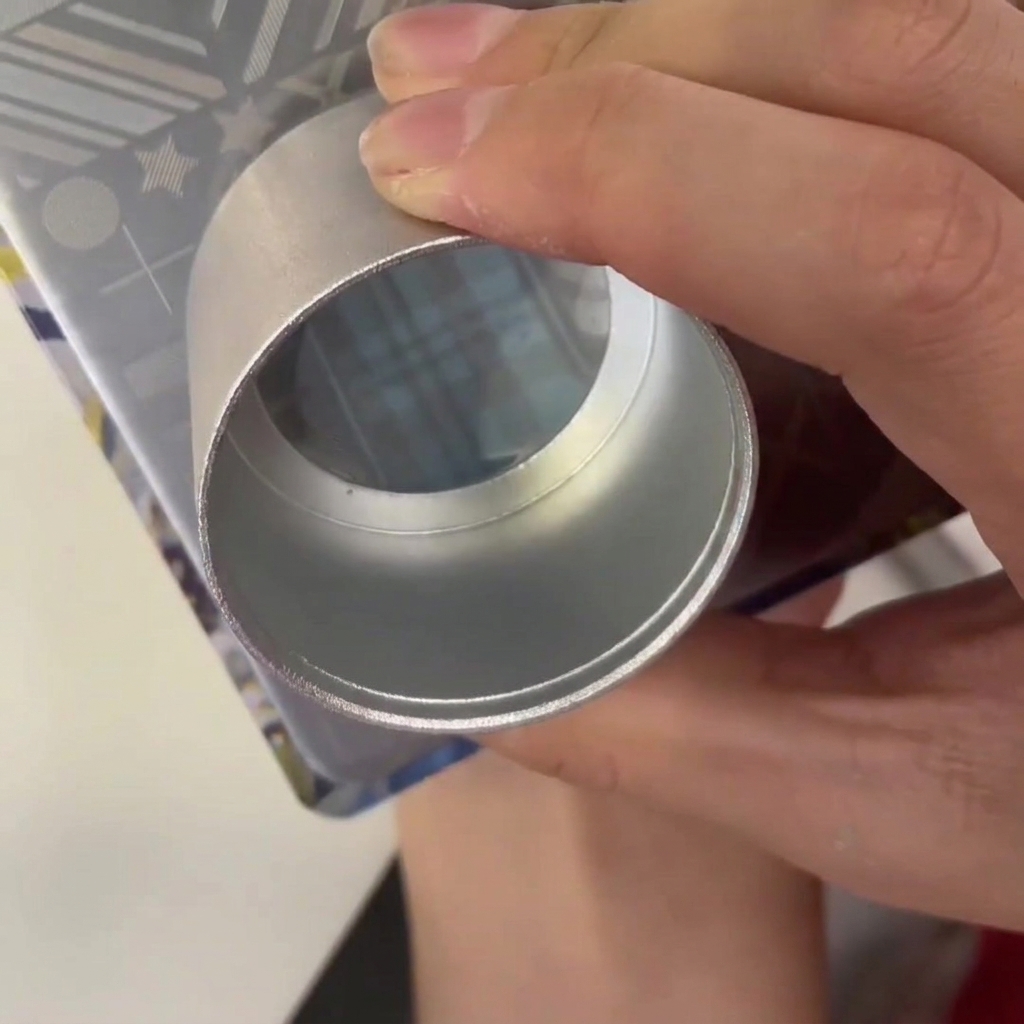 Ein Kunststoffabzieher wird über eine Metall-Stamping-Platte mit blauem Lack in der Gravur gezogen.