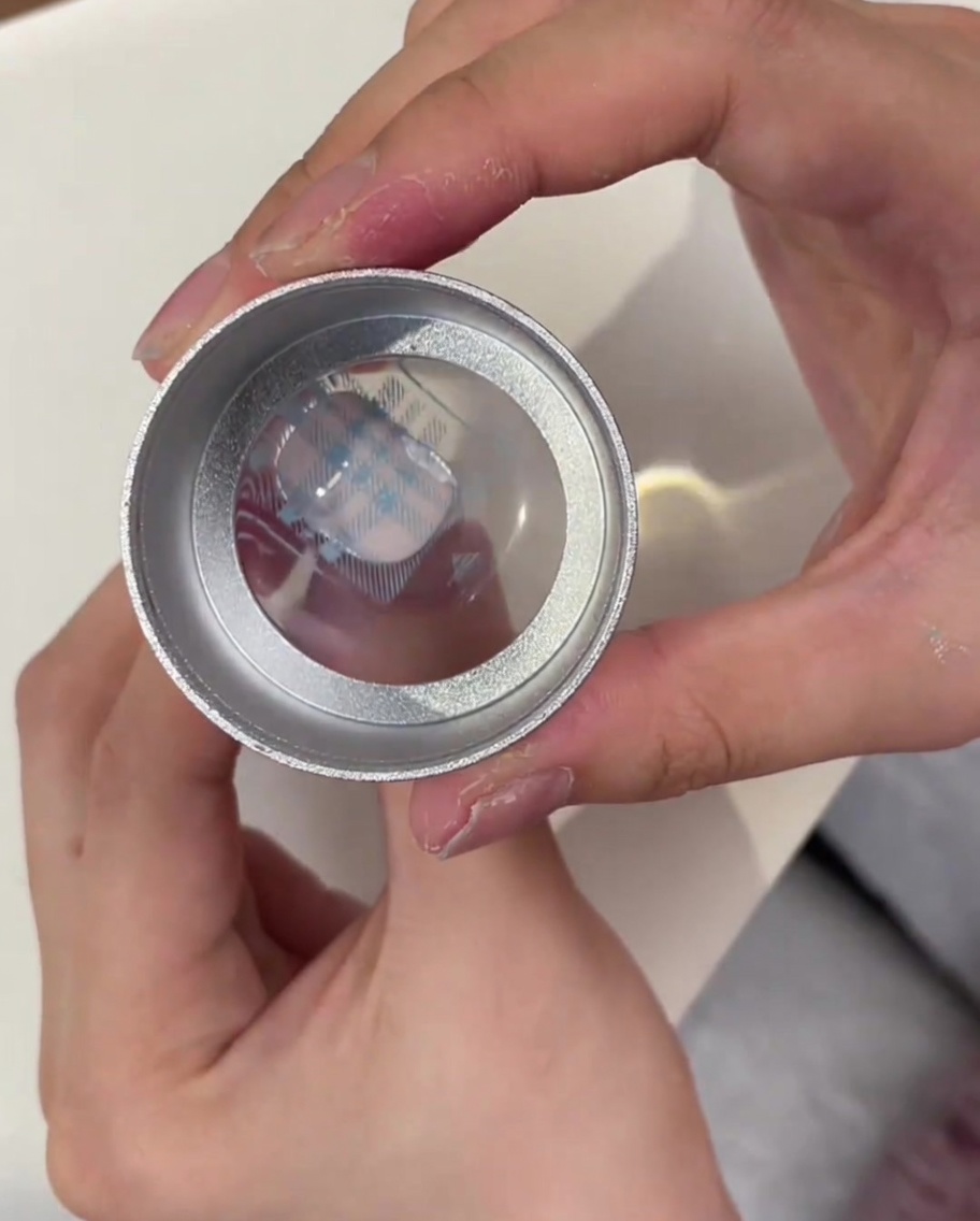 Ein klarer Jelly-Stamper-Kopf zeigt das aufgenommene blaue Plaid-Muster von der Metallplatte.