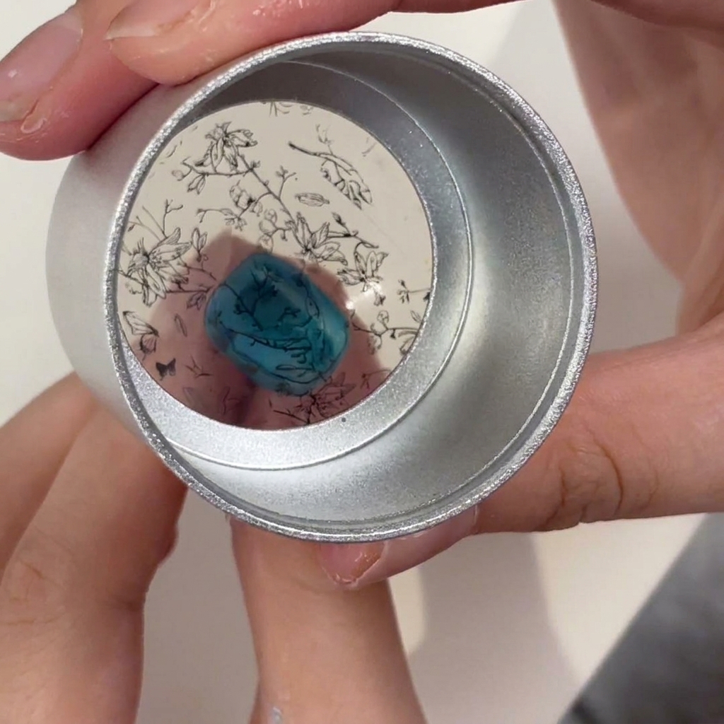 Ein Jelly-Stamper über einem türkisen Nagel mit ausgerichtetem schwarzem Blumenmuster.