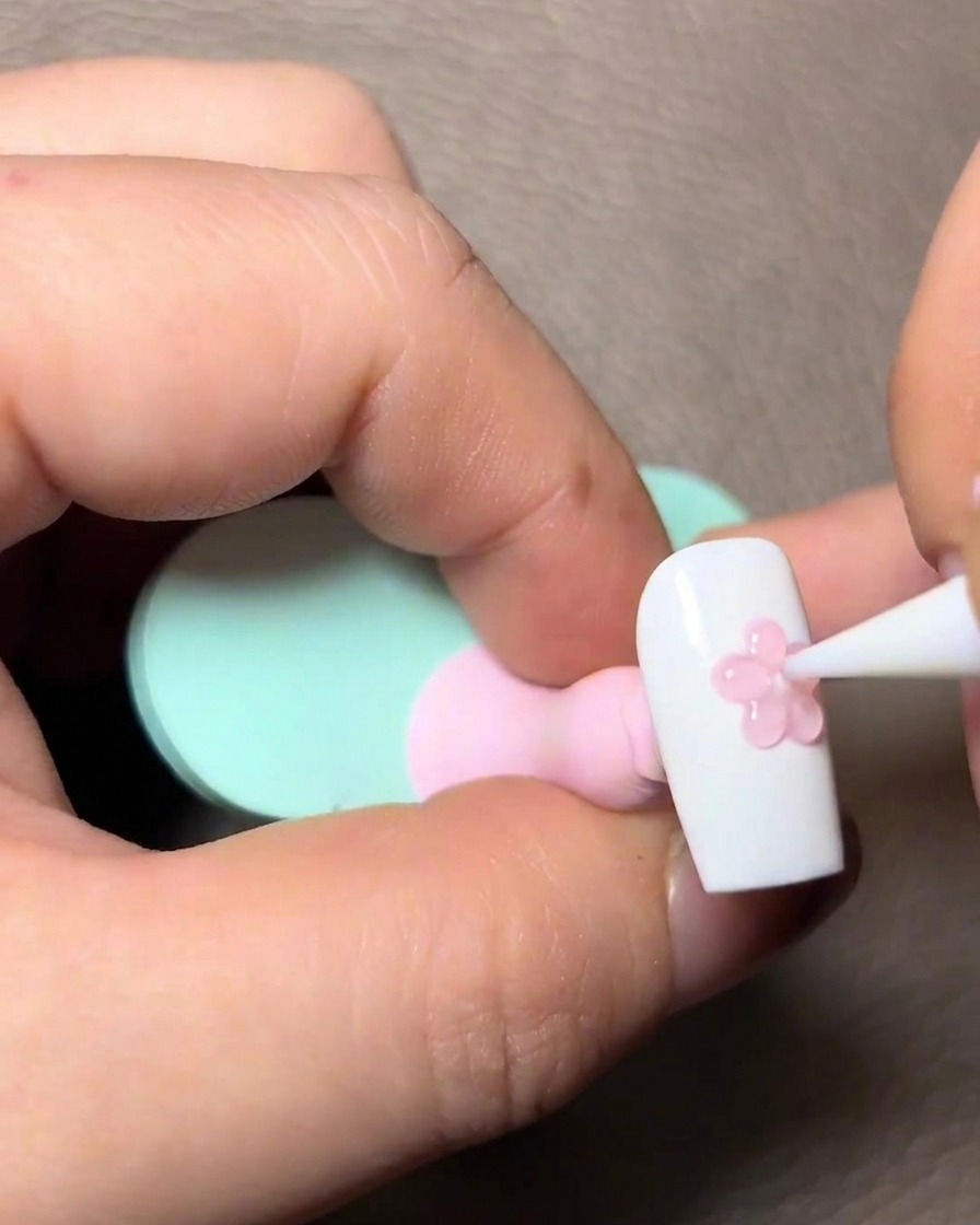 Auftragen von transparentem, rosafarbenem Gel über die ausgehärteten 3D-Pfotendetails auf dem Nagel.