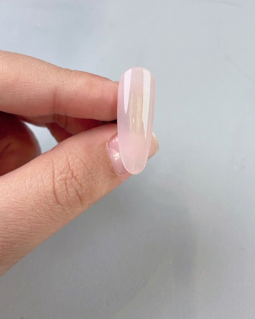 Eine klare, leicht milchige Jade-Gelbasis wird auf einen Naturnagel aufgetragen.