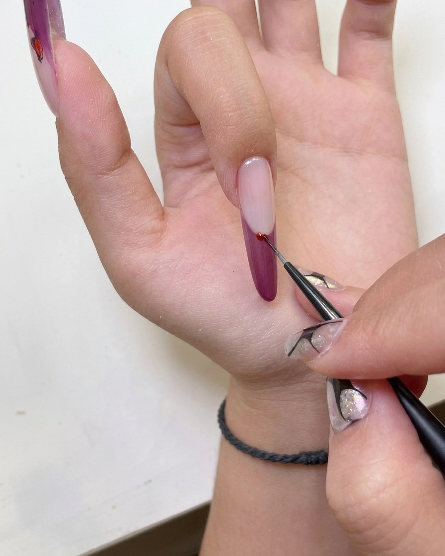 Nahaufnahme einer Hand mit Cat-Eye French Nailart in einer UV-Nagellampe.
