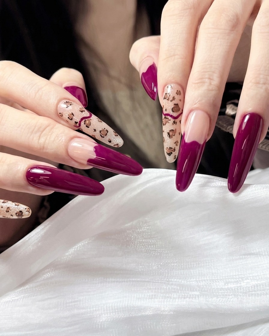 Nahaufnahme eines feinen Nail-Art-Pinsels, der kleine, unregelmäßige braune Flecken auf einen nudefarbenen Nagel zeichnet.