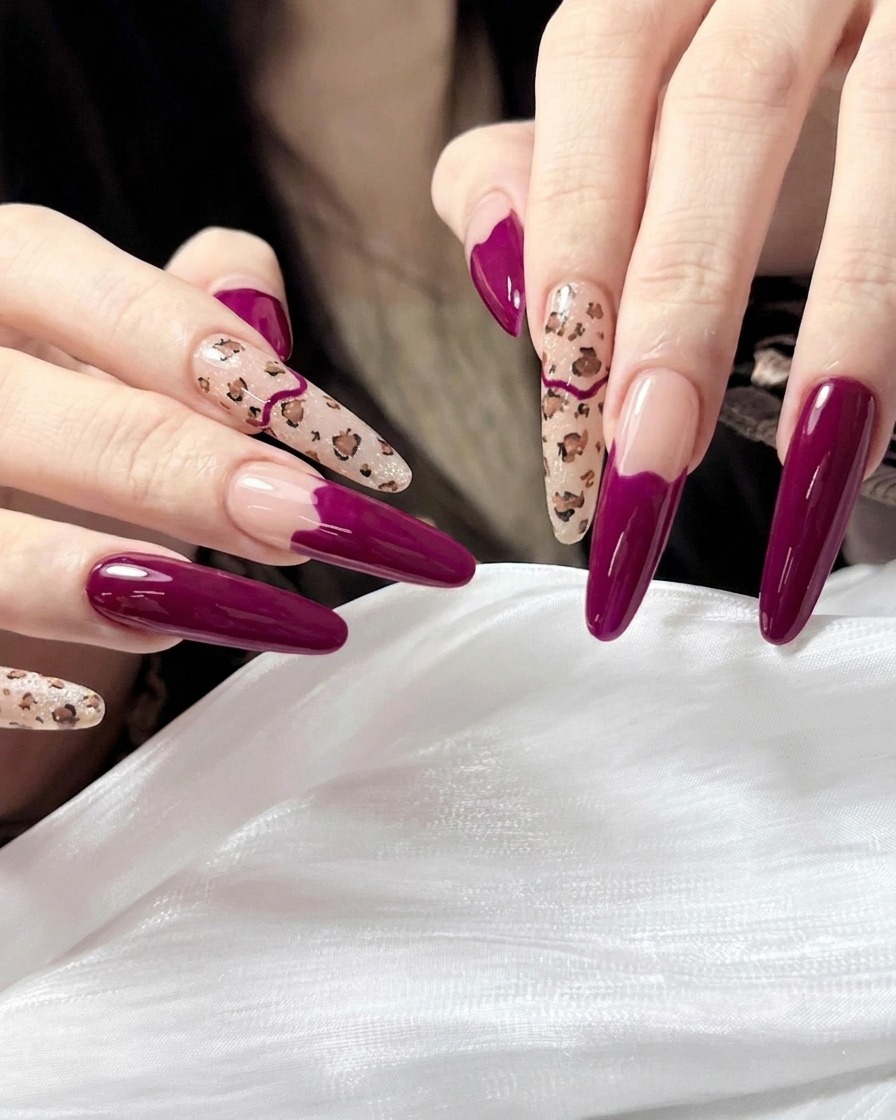 Ein Pinsel trägt einen klaren, hochglänzenden Top Coat auf die fertige Maniküre mit Leopardenmuster und Magenta auf.