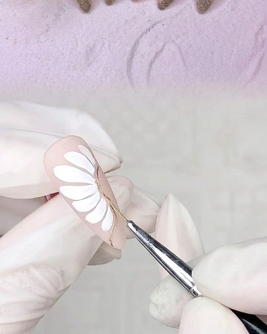 Hand mit dekoriertem Nagel in einer UV-Nagellampe.