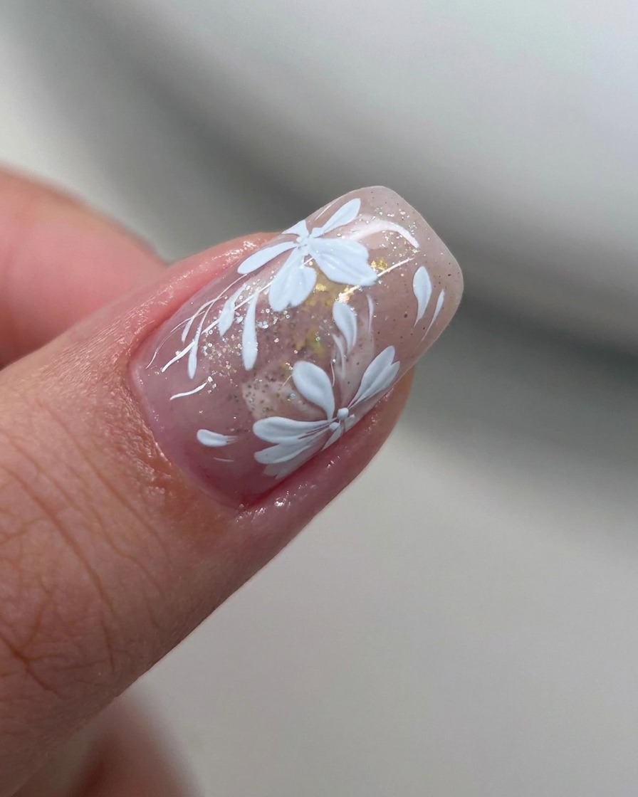 Ein flacher Pinsel verblendet die Kanten des weißen Gel-Lacks auf dem Nagel.