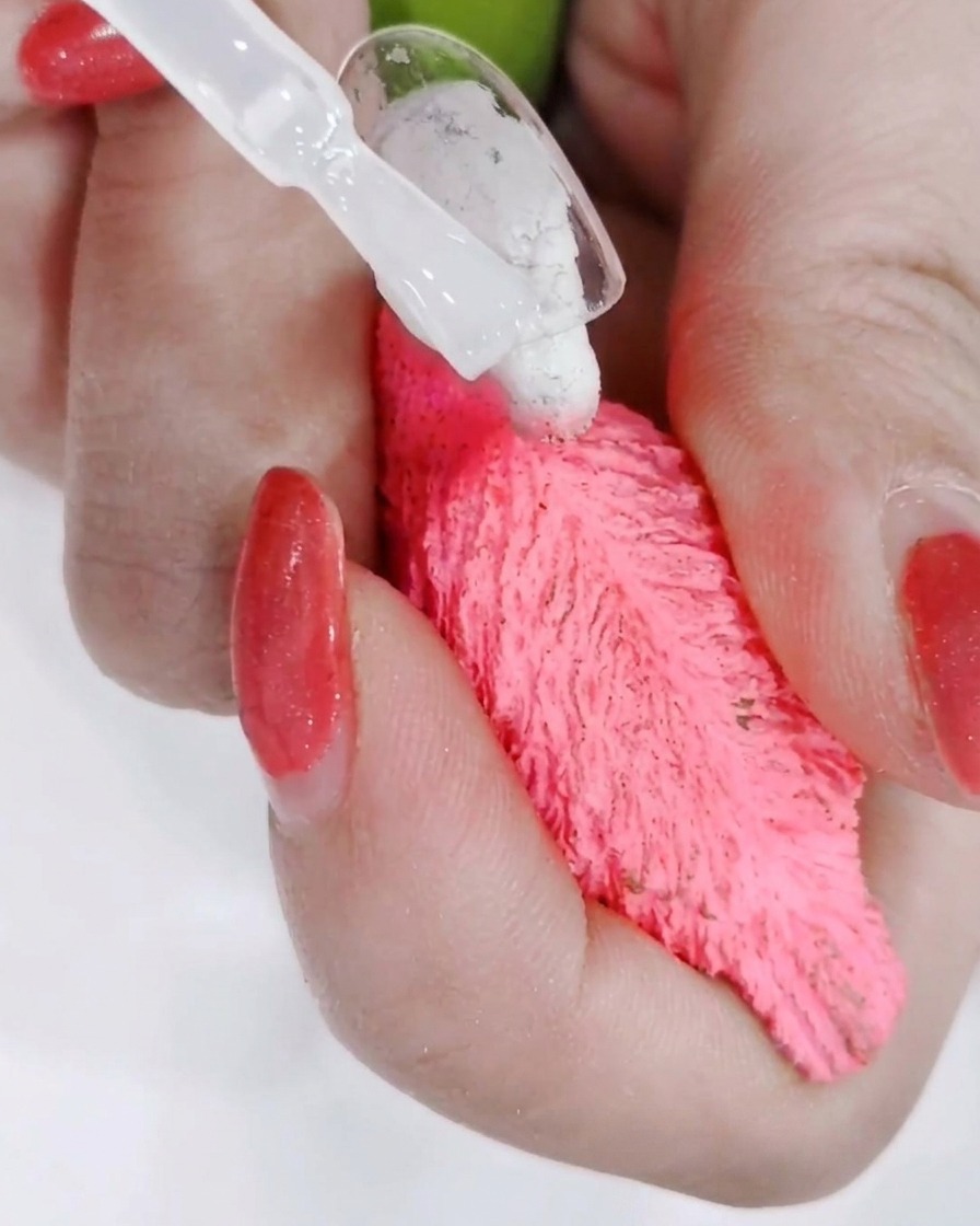 Eine Hand unter einer professionellen UV-Lampe, während das Licht den Top-Coat aushärtet.