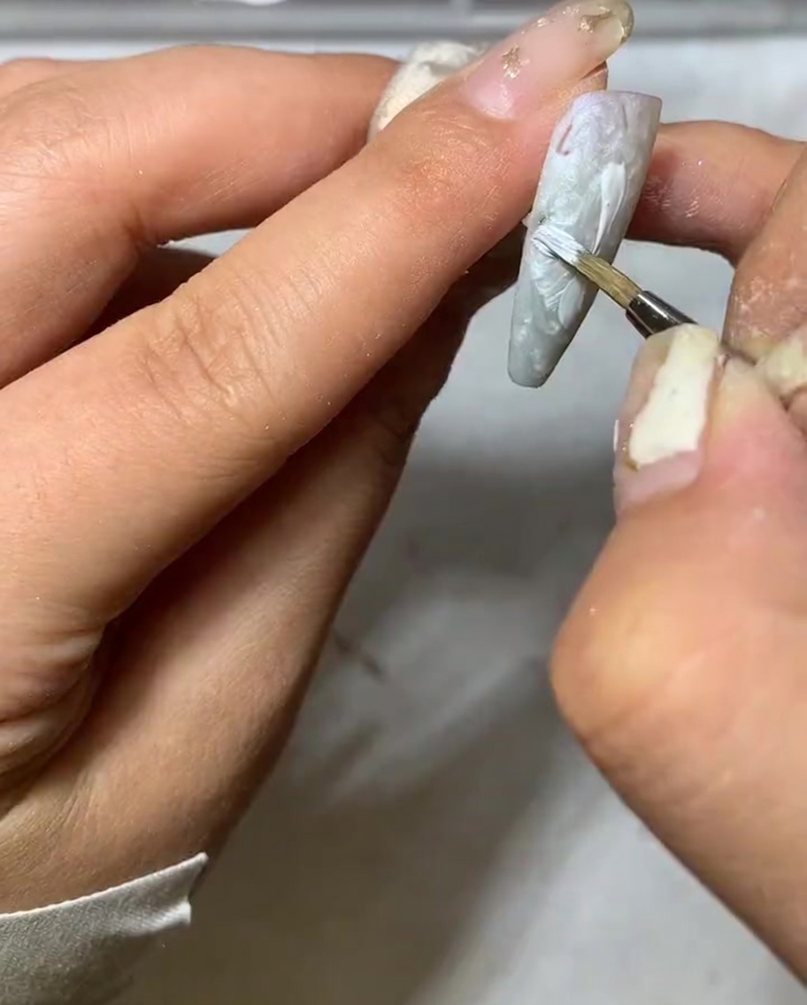 Detailaufnahme, wie die Spitze eines Liner-Pinsels das Ende eines weißen Gänseblümchen-Blütenblattes verjüngt.