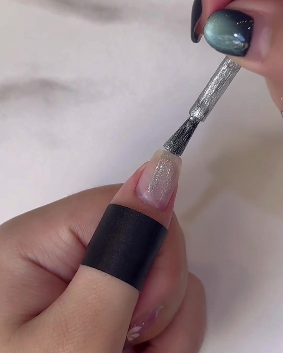 Finger mit bemalten Stängeln unter der UV/LED-Lampe.