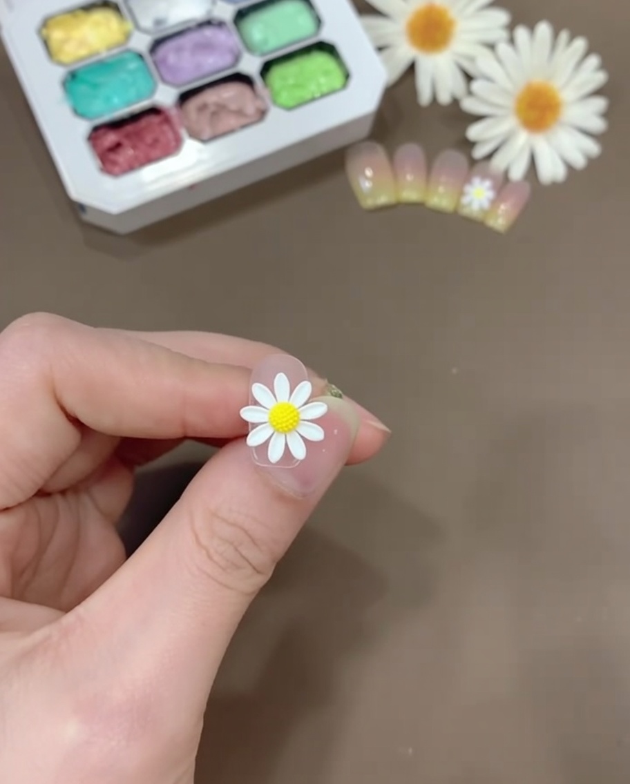 Eine kleine Menge gelbes Gel gemischt mit klarem Base Coat auf einer Kunststoffpalette.