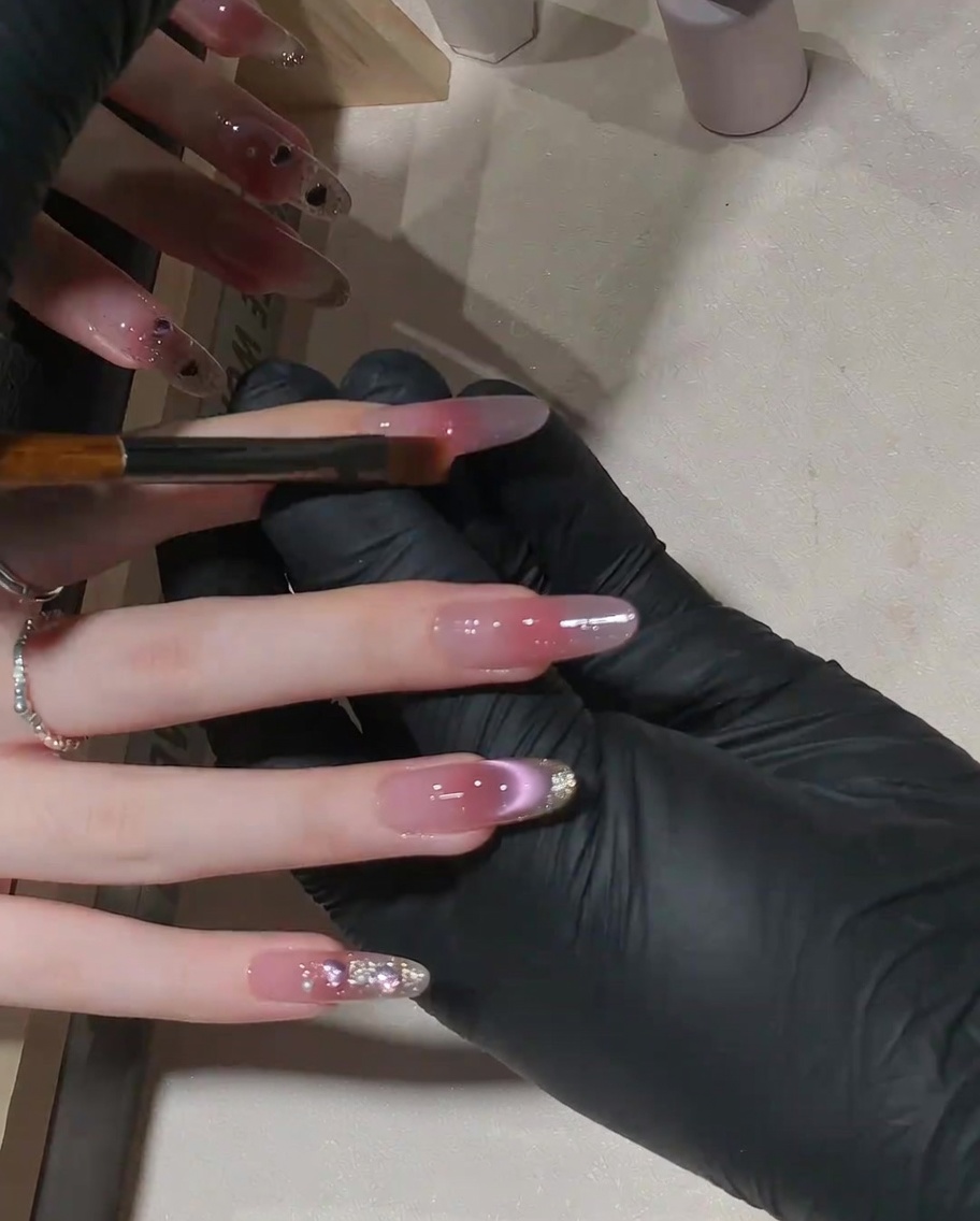Ein kleiner flacher Pinsel wird verwendet, um das rosa Gel für einen Gradienten-Effekt nach oben auf dem Nagel zu verstreichen.
