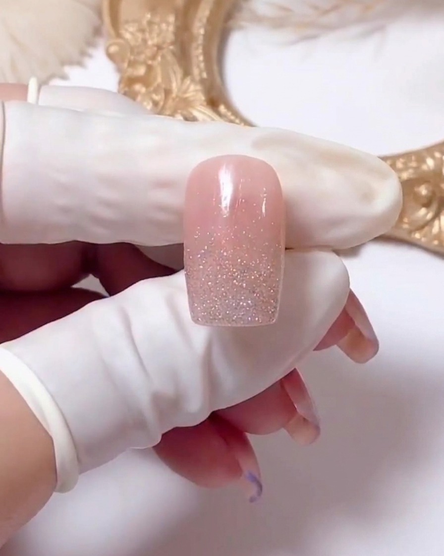 Nahaufnahme eines Nagels, der zeigt, wie weiße Gellinien in X-Form gezeichnet werden, um ein Gänseblümchen-Design zu beginnen.