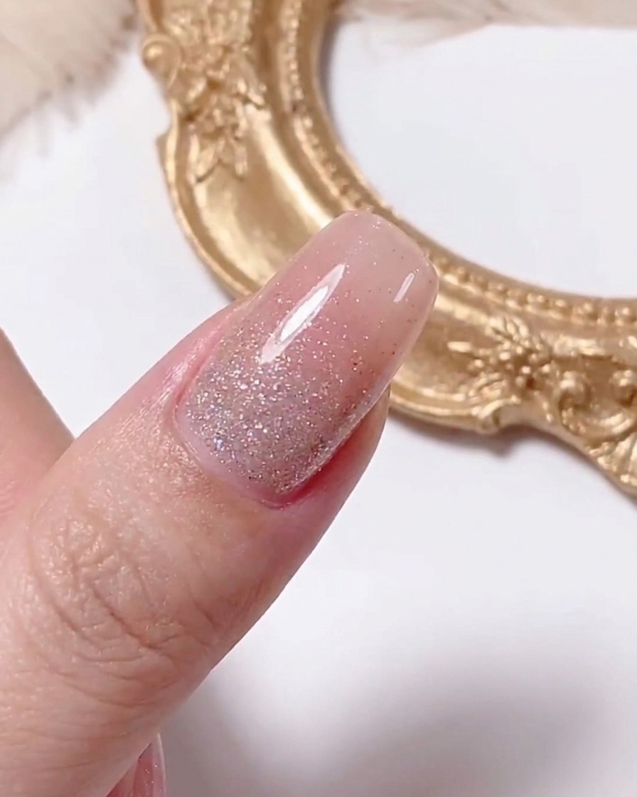 Ein Punktierwerkzeug trägt einen kleinen gelben Punkt in die Mitte eines weißen Gänseblümchen-Designs auf einem Nagel auf.