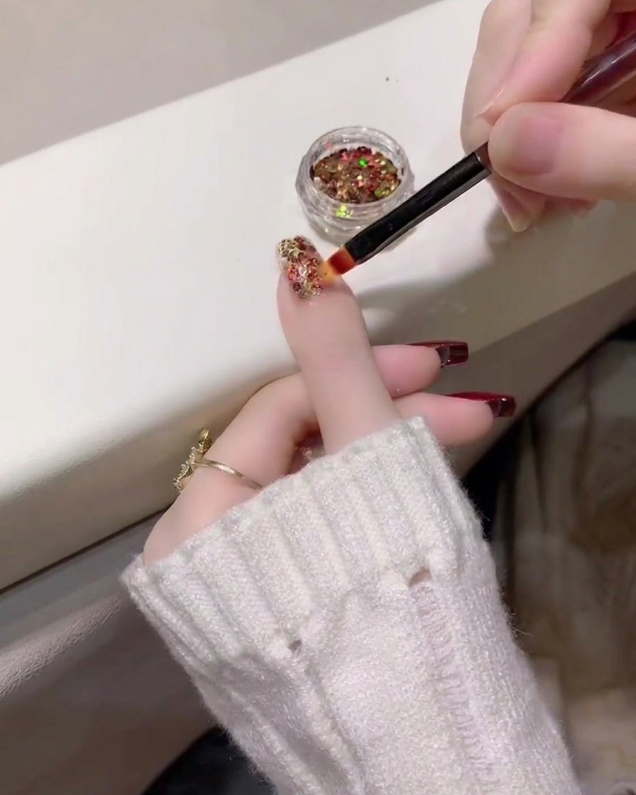 Nahaufnahme einer dichten Glitzerschicht auf dem Ringfingernagel.