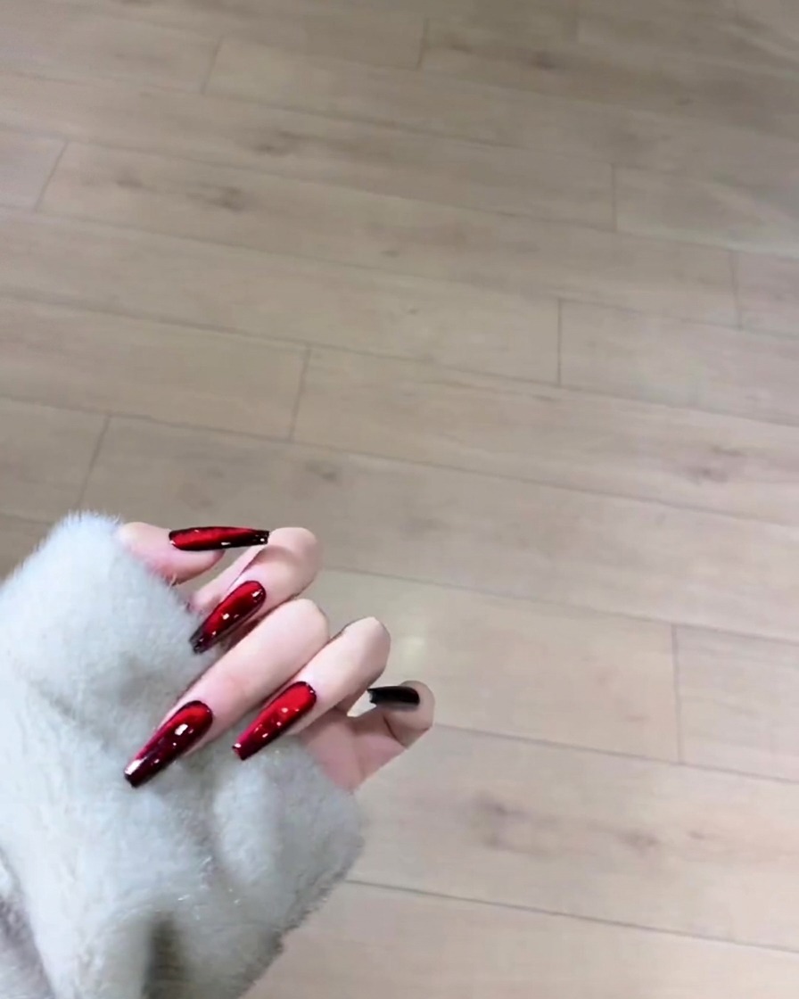 Ein Pinsel trägt eine glatte Schicht schwarzen Gel-Lacks auf die gesamte Oberfläche eines naturlangen Nagels auf.