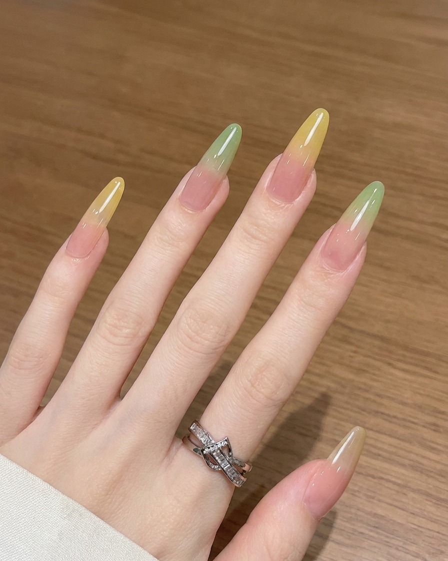 Nahaufnahme eines Ombré-Pinsels, der gelbes Gel auf einem Nagel nach oben hin verblendet.