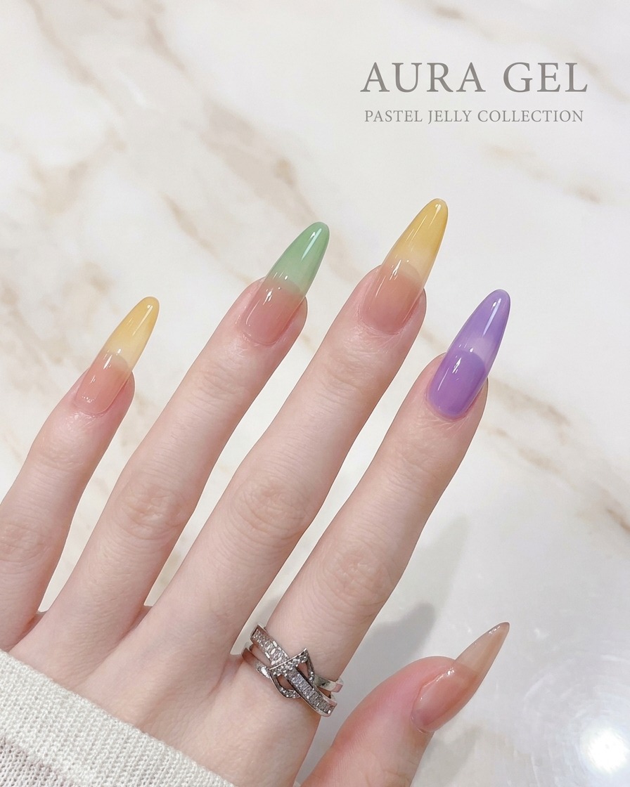 Nahaufnahme eines Pinsels, der violettes Jelly-Gel auf die Spitze eines Nagels aufträgt.