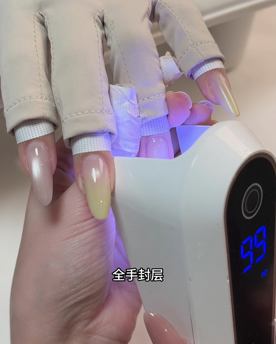 Eine Hand in einer professionellen UV-Nagellampe während des Aushärtungsprozesses.