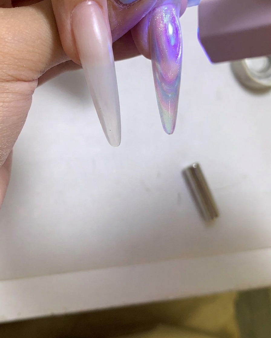 Eine tragbare UV/LED-Lampe härtet einen glänzenden Cat-Eye-Gelnagel.