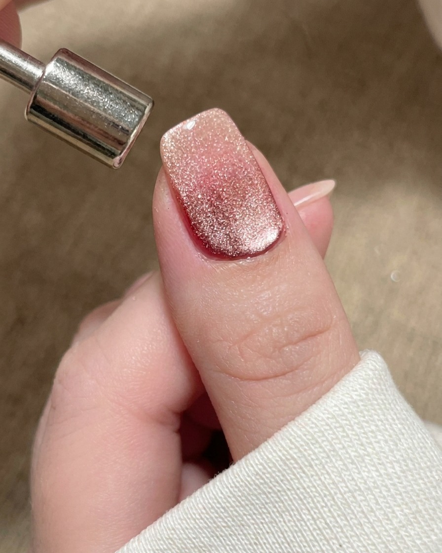 Nahaufnahme eines Magneten, der verwendet wird, um den magnetischen Schimmer zur freien Nagelspitze hin zu schieben.