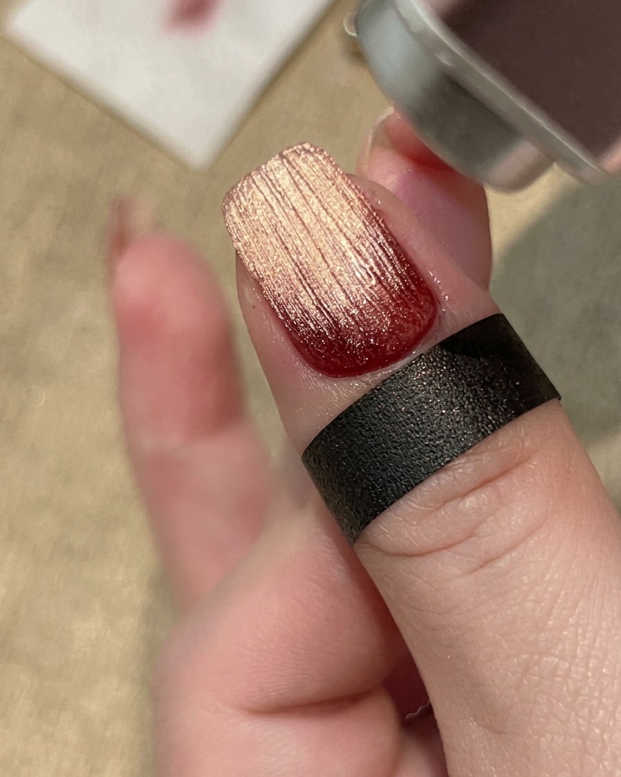 Eine Hand härtet ein texturiertes Gel-Nageldesign unter einer professionellen UV/LED-Lampe aus.