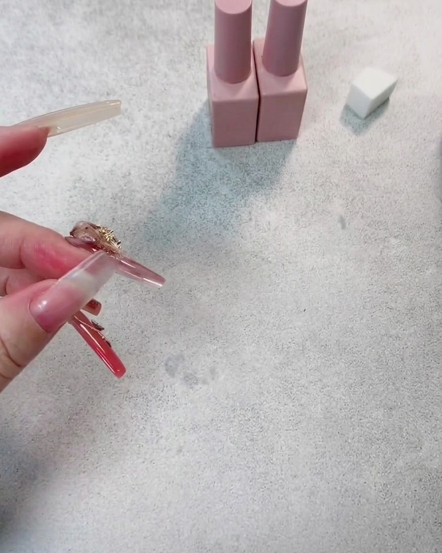 Nahaufnahme eines Nagels bei der zweiten Schicht Dunkelrot, die für mehr Farbtiefe sorgt.
