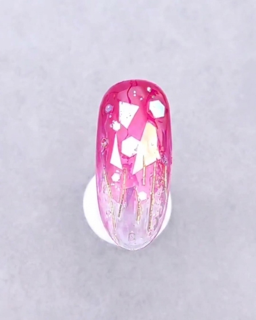 Ein Nagel mit platzierten Dekorationen unter dem violetten Licht einer UV-Nagellampe positioniert.