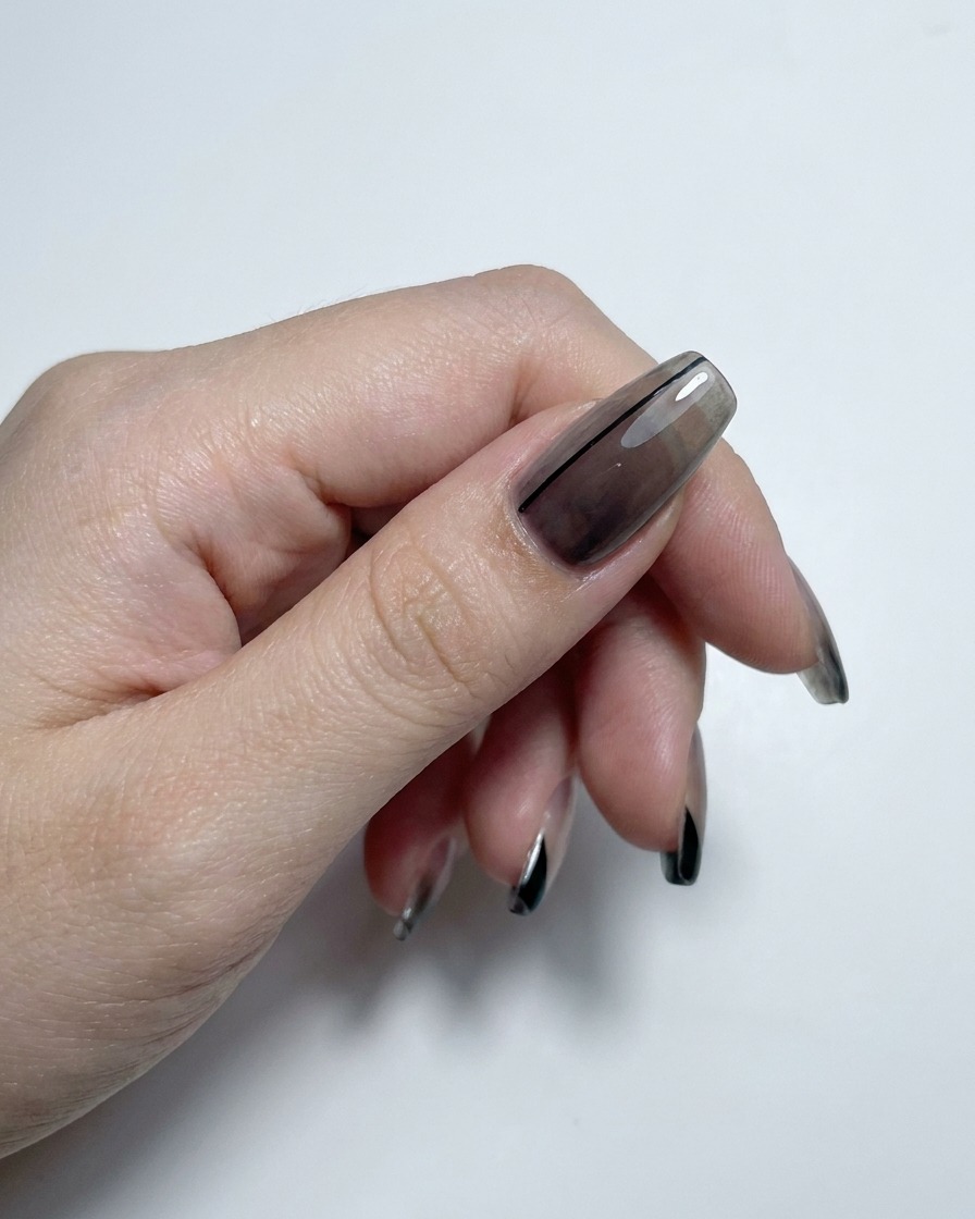 Eine Hand zeigt durchscheinende Gradient- und French-Tip-Nägel, die mit einem Hochglanz-Top-Coat veredelt wurden.