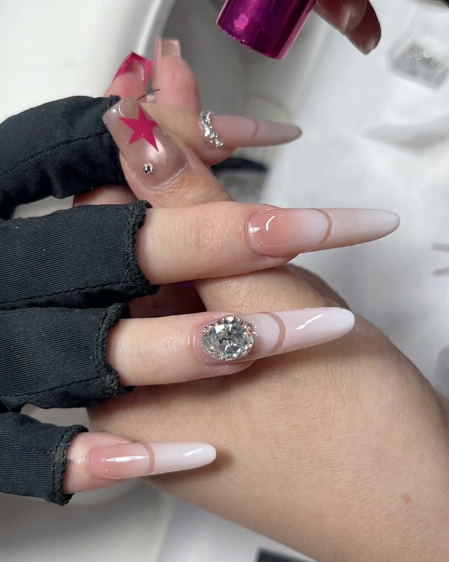Eine Hand positioniert unter einer kompakten rosa UV/LED-Nagelhärteleuchte mit dekorativer Nail-Art.